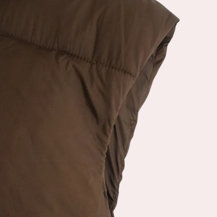 Stylish women's short quilted vest. Ideal for spring/fall, offering warmth without bulk. Trendy layering bodywarmer.