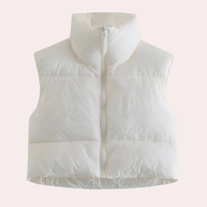 Women's short quilted bodywarmer, a sleek vest for layering. Modern polyester outerwear, perfect for transitional seasons.