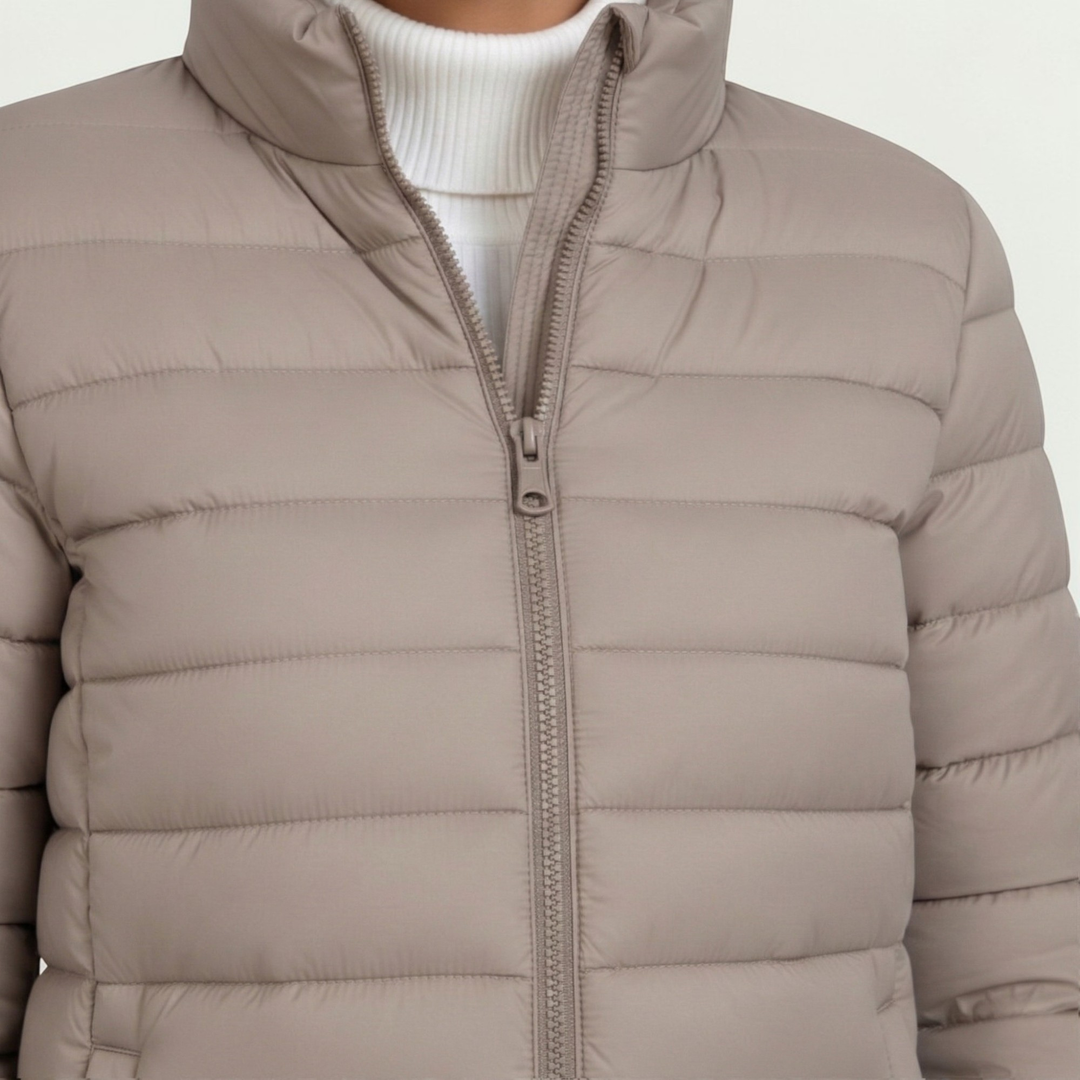 Close-up of women's warm quilted jacket fabric with detailed stitching & stand collar. Slim fit outerwear.