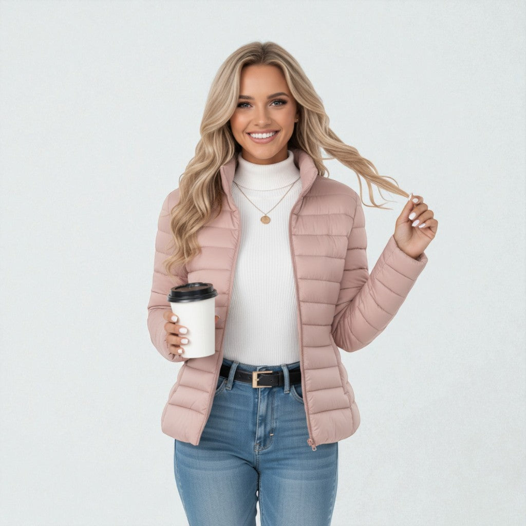 Woman walking in a warm quilted jacket. Stand collar, full zip for everyday wear & winter comfort.