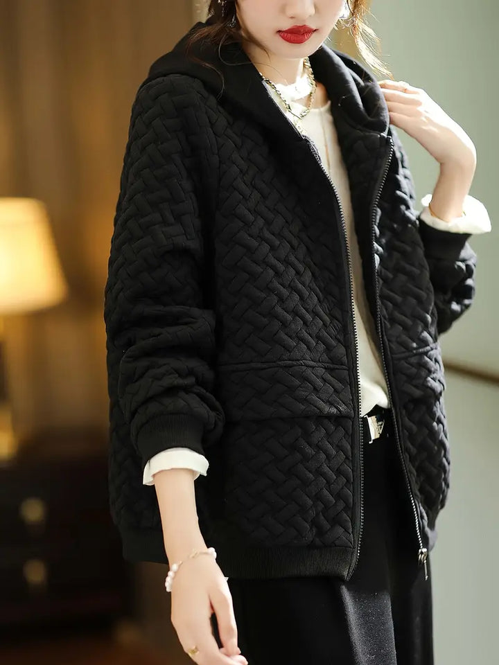 Women's quilted zip-up hoodie with practical pockets, blending cozy comfort with functional style.