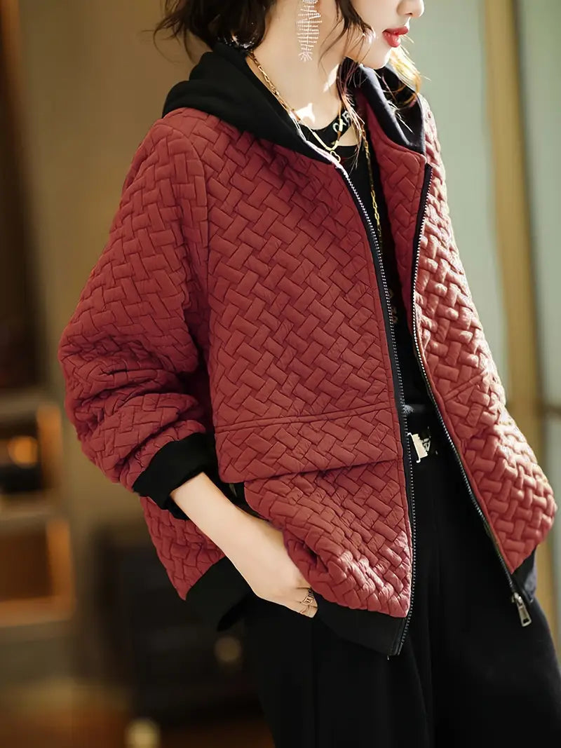 Back view of a woman in a stylish quilted zip-up hoodie, showing the cozy hooded design.