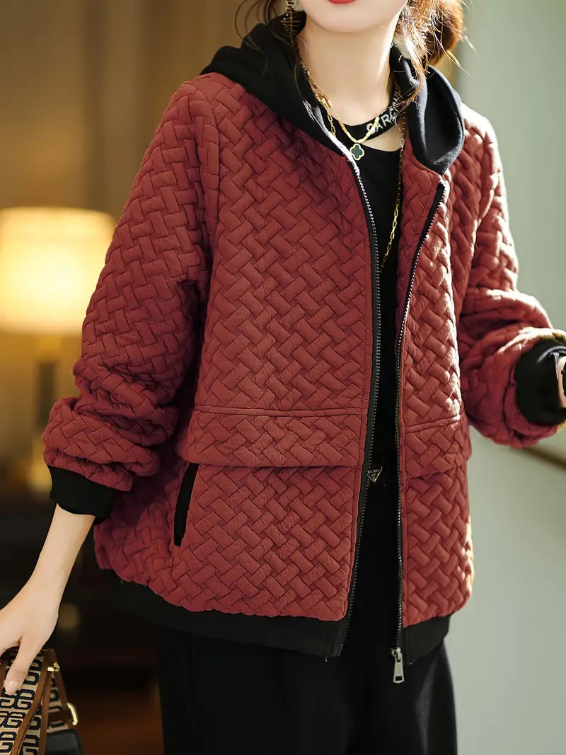 Detail of the smooth zip-up closure on a women's quilted hoodie, enhancing its casual chic style.