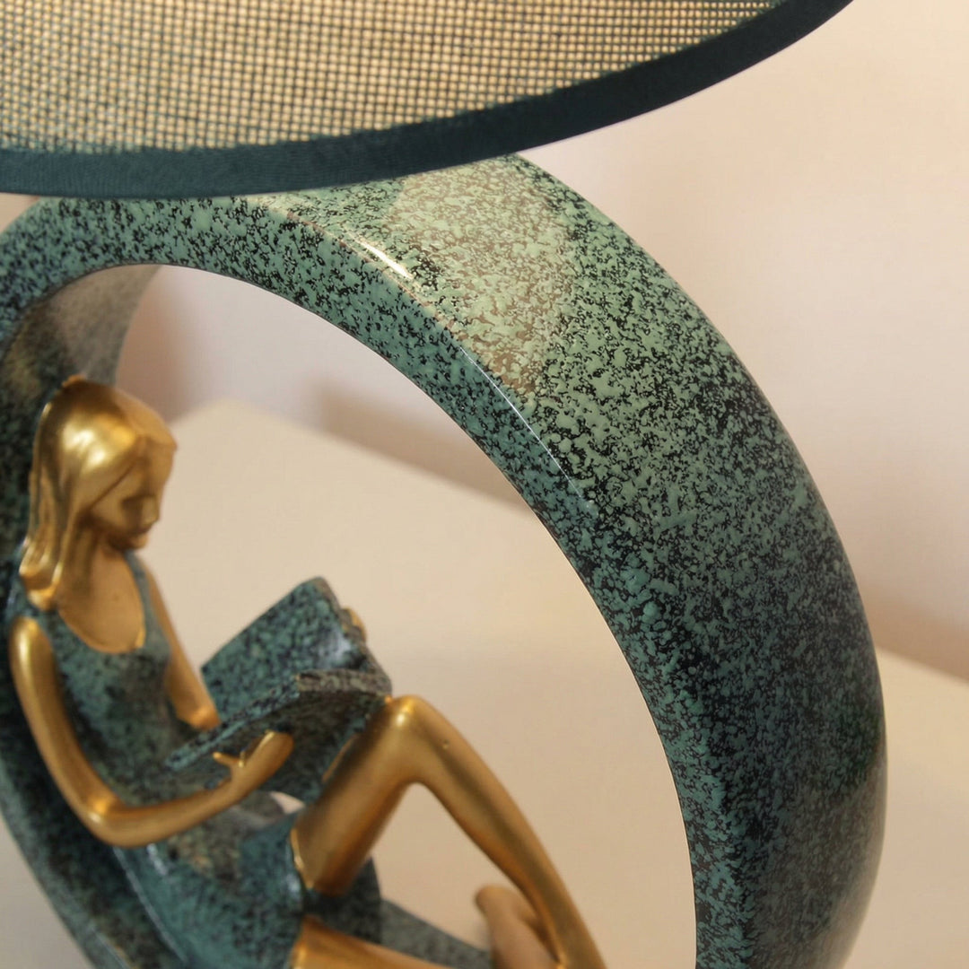 Women's Reading Sculpture Table Lamp, a unique decorative lighting piece with a fabric shade and resin figurine base, en
