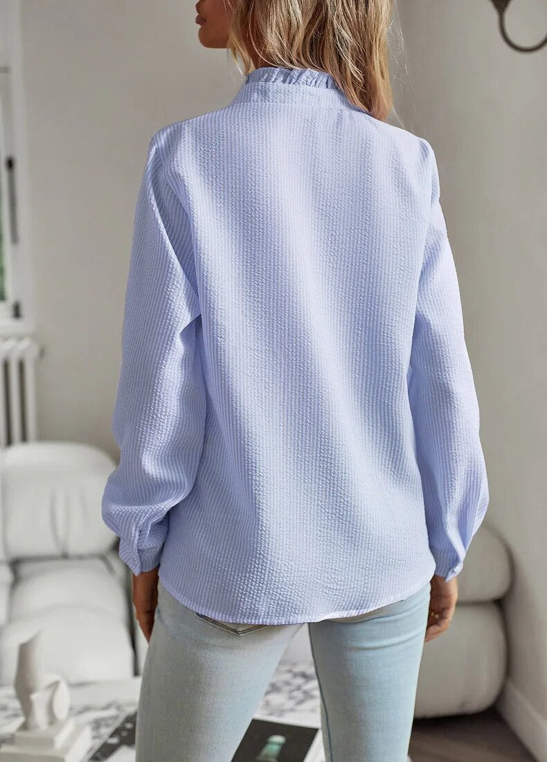 Trendy women's long sleeve blouse featuring a unique mullet hem and vibrant print.