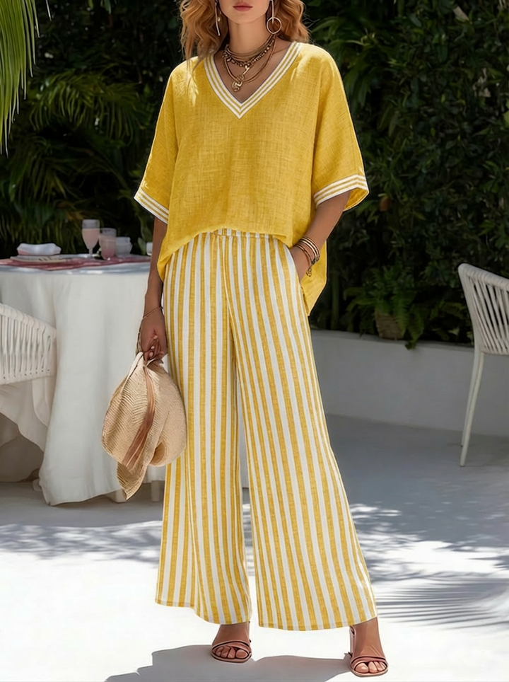 Fashionable ladies' striped summer two-piece set; relaxed fit V-neck top & wide-leg pants for a chic vacation look.