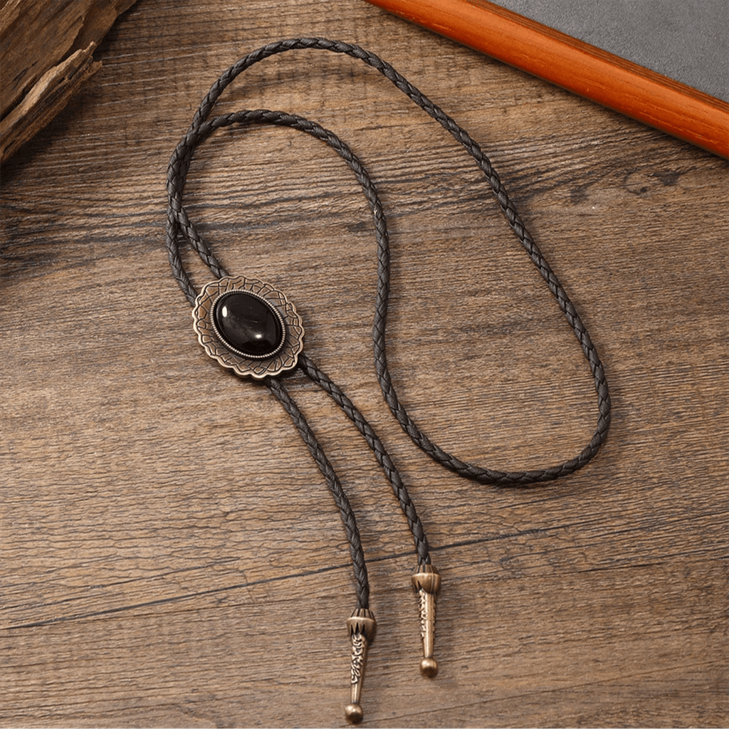 Western-style women's bolo tie, showcasing a tribal turquoise & onyx pendant on a braided leather cord.