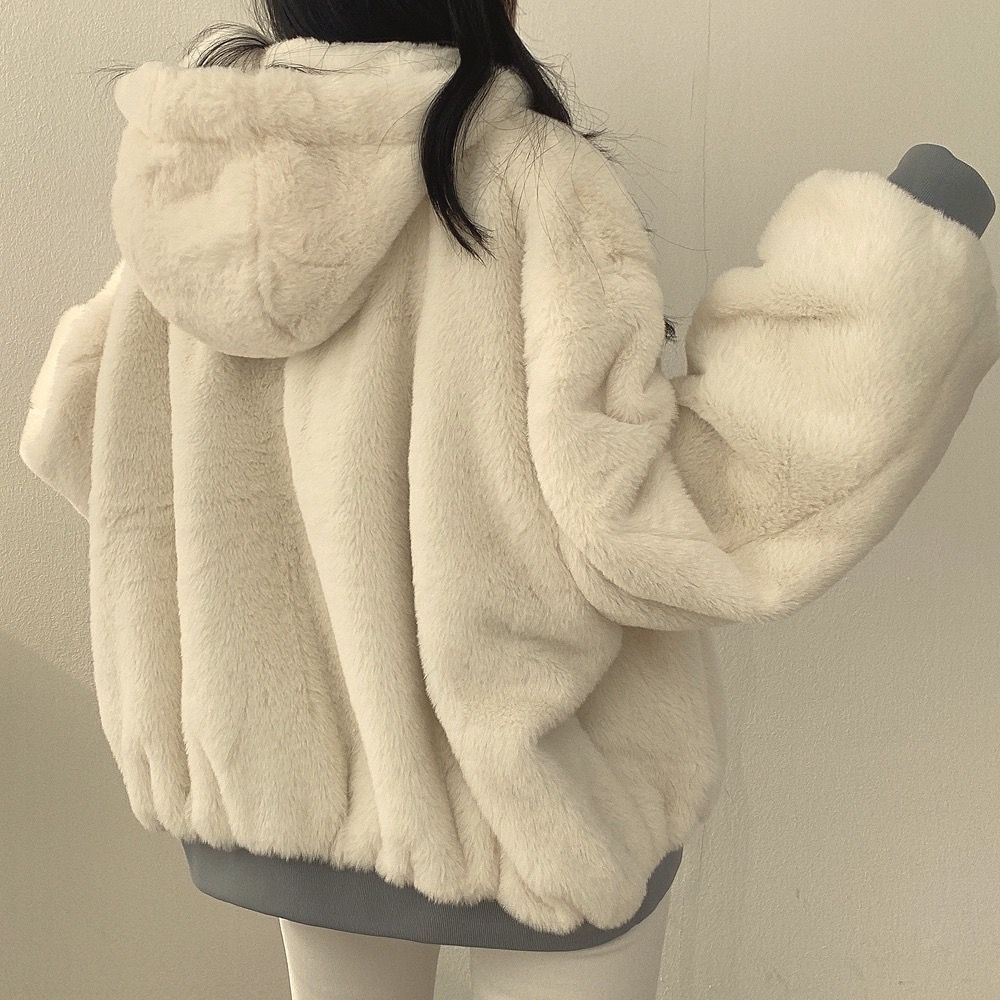 Woman wearing black reversible hooded jacket, warm & versatile winter outerwear.