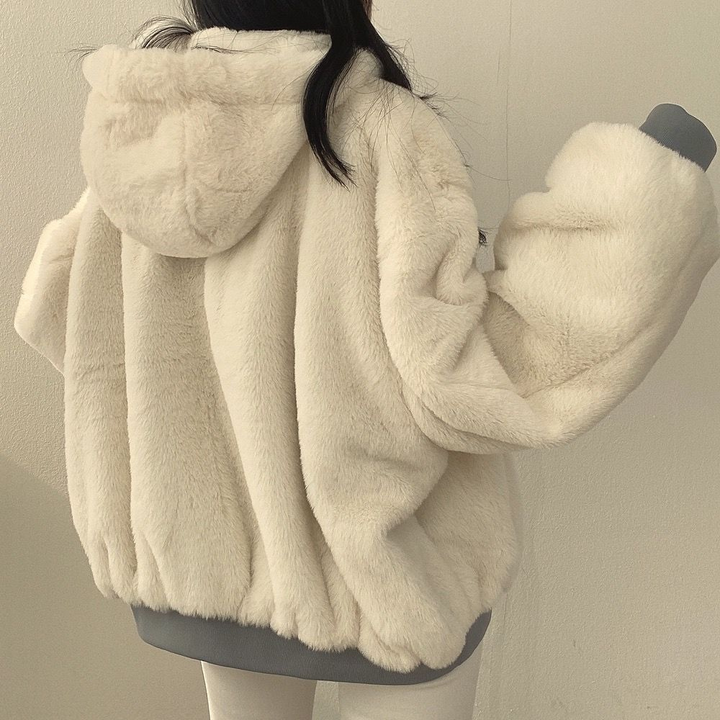 Woman wearing black reversible hooded jacket, warm & versatile winter outerwear.