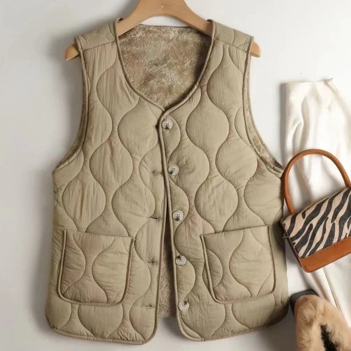Khaki women's reversible quilted vest with button-up front, a stylish sleeveless jacket for fall layering.