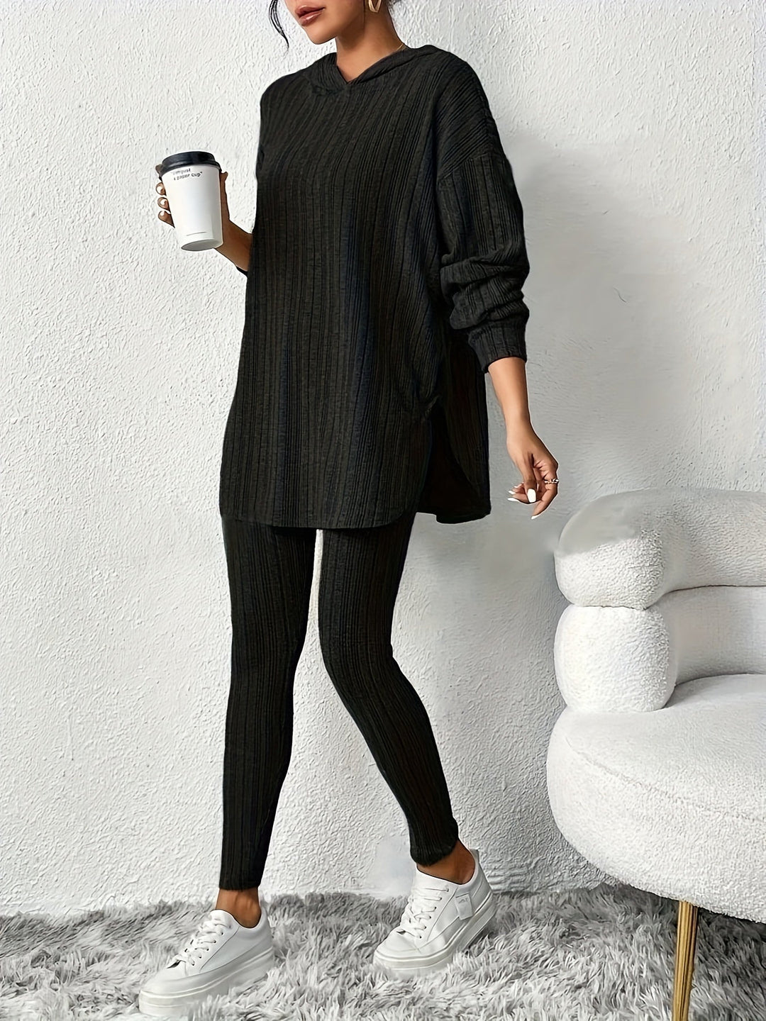 Woman relaxing in a comfy blue ribbed knit lounge set. Two-piece loungewear for ultimate comfort.