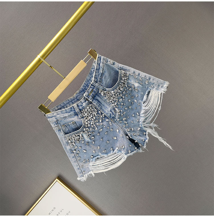 Stylish women's wide-leg ripped shorts, ideal for summer fashion. Distressed high-waist denim, perfect for casual spring style.