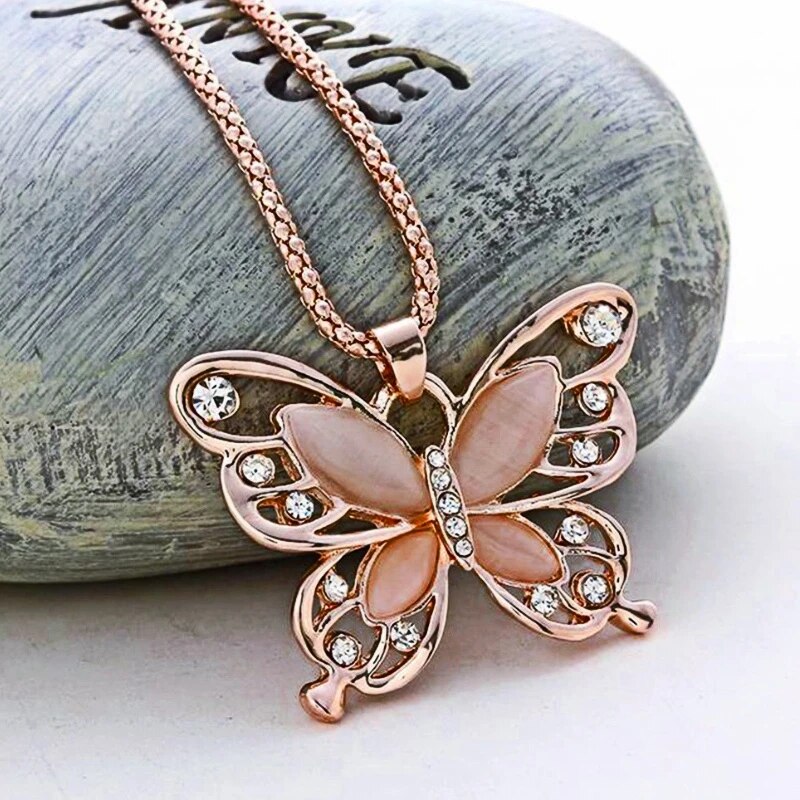 Elegant rose gold necklace featuring a shimmering opal butterfly charm, a beautiful gemstone jewelry piece.