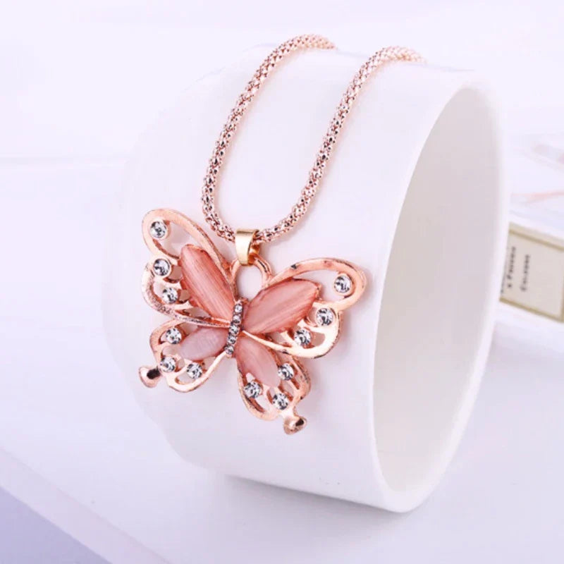 Delicate rose gold butterfly necklace with vibrant opal, a stylish and feminine women's fashion statement.