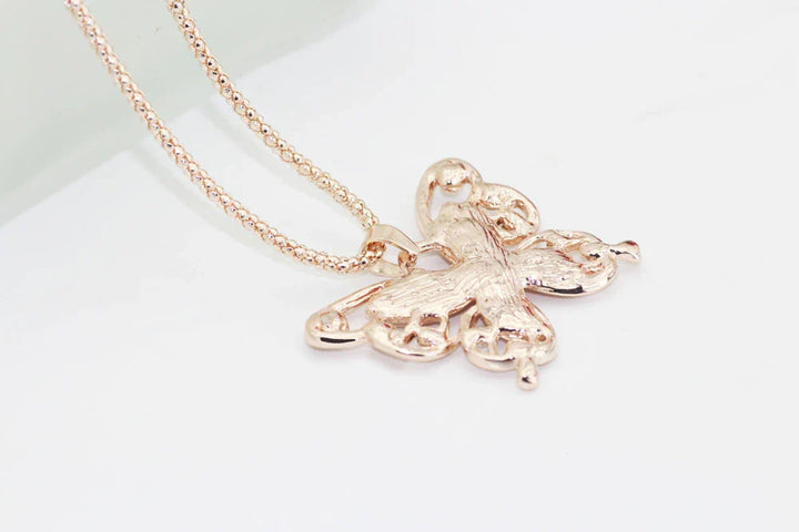 Close-up of a women's rose gold necklace, showcasing the iridescent opal butterfly gemstone pendant.
