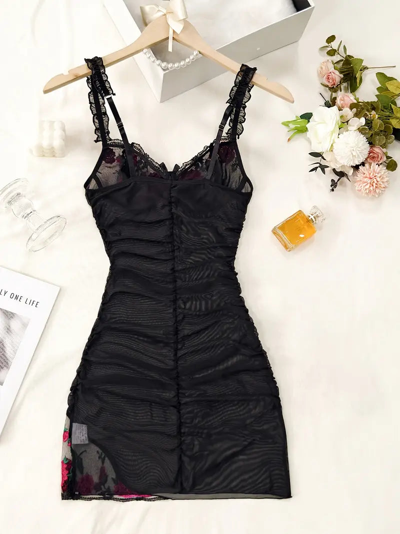 Close-up of the delicate floral embroidery on a sheer ruched mesh women's nightgown.