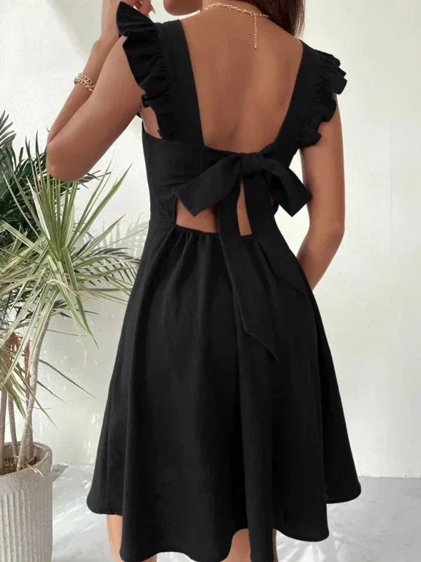 Flirty women's mini dress with ruffle straps, A-line cut, and a playful bow back design.