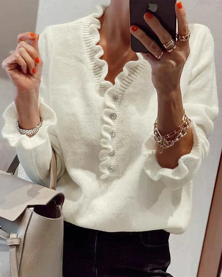 Stylish women's ruffled knit sweater. Comfortable long sleeve top with button accents for versatile everyday wear.