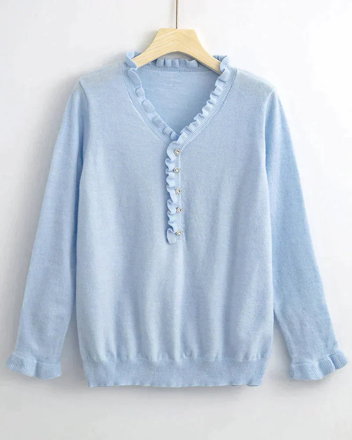 Soft knit women's top featuring delicate ruffles and button details. Perfect for a cozy and chic casual outfit.