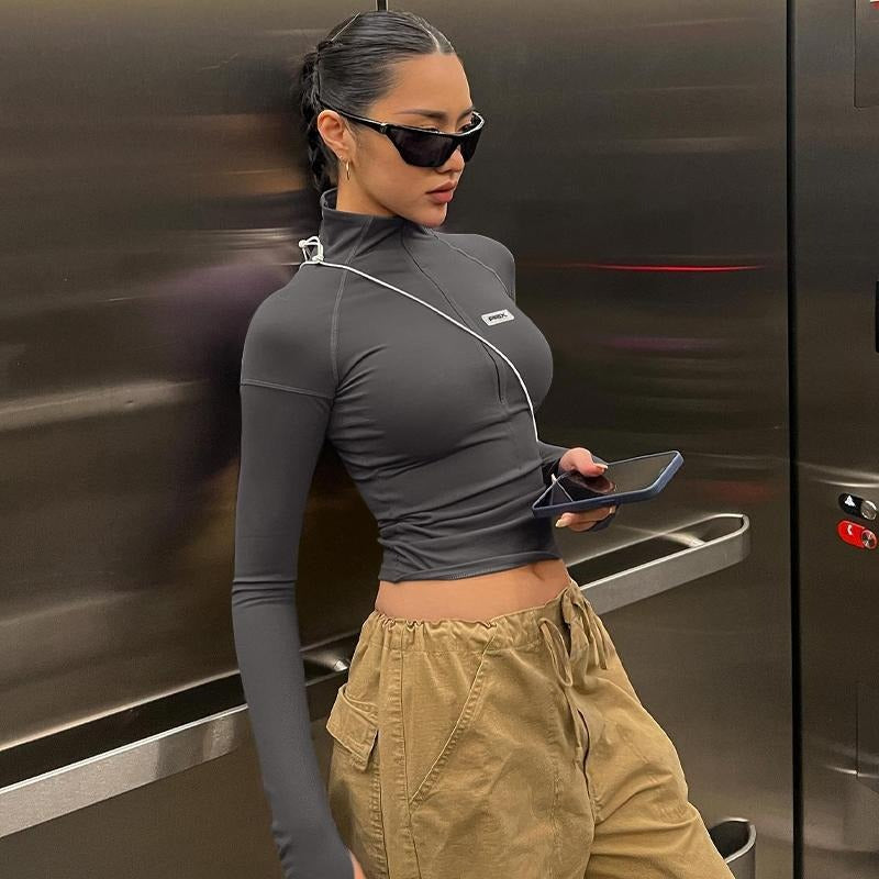 Fashionable women's sculpting zip-up long sleeve crop top, a key piece for modern apparel.