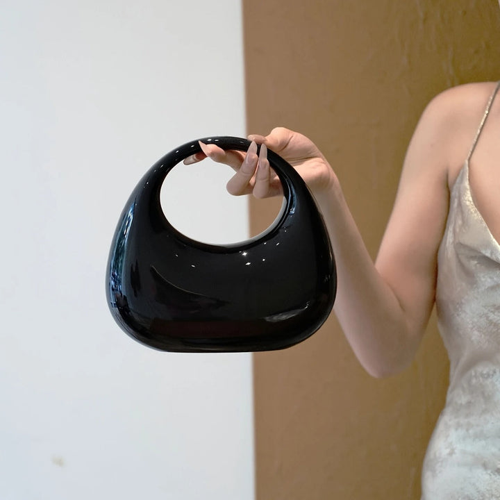 Women's sophisticated sculptural acrylic clutch bag, evening accessory.