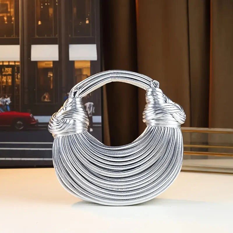 Sculptural women's vegan leather handbag, features a convenient detachable and adjustable strap.