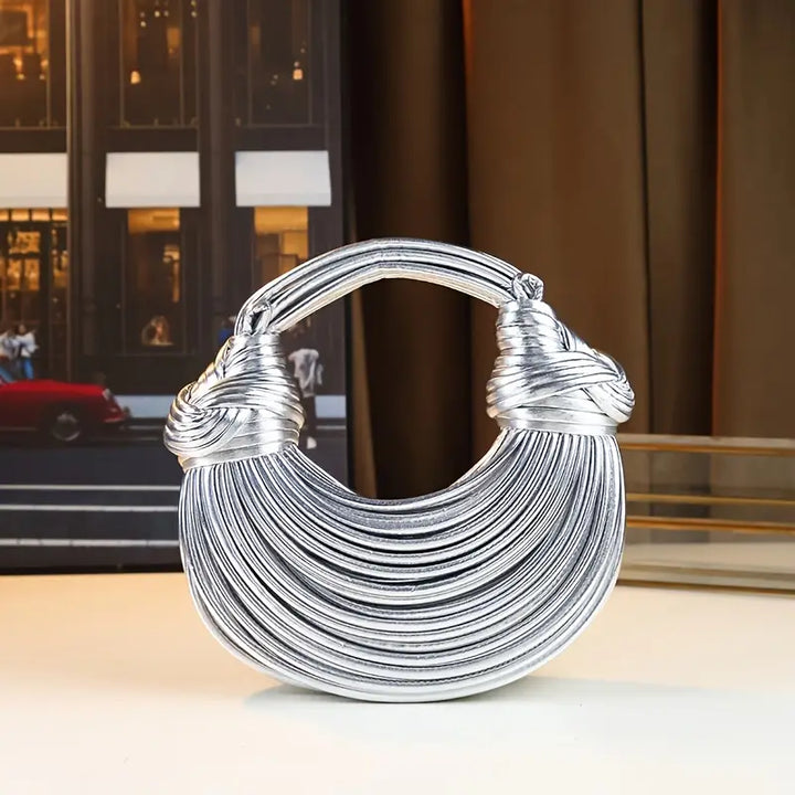 Sculptural women's vegan leather handbag, features a convenient detachable and adjustable strap.