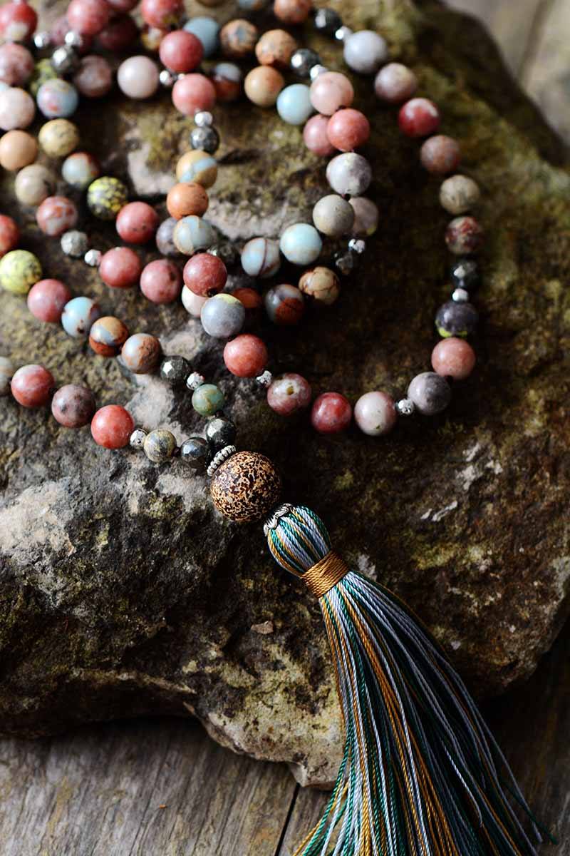 Close-up of Seraphina rhodonite & hematite gemstone mala necklace, women's spiritual healing yoga accessory.