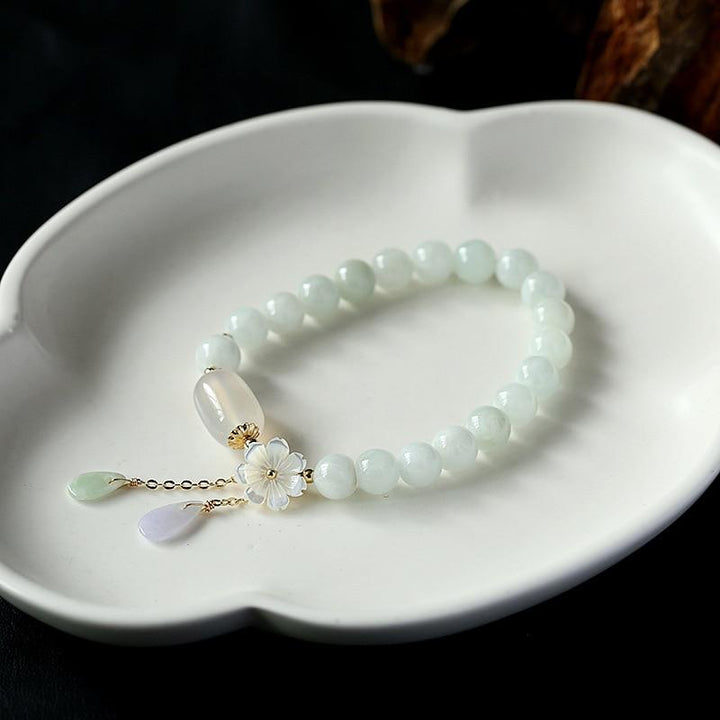Elegant women's jade and agate crystal bracelet, perfect for serenity and healing, on a velvet display