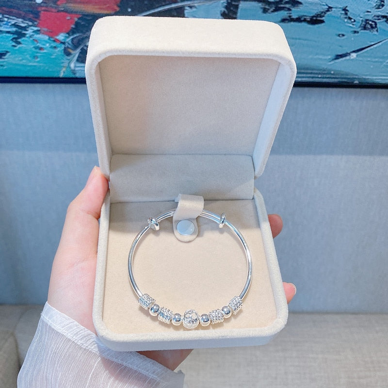 Elegant women's hypoallergenic silver bracelet with shimmering luck beads.