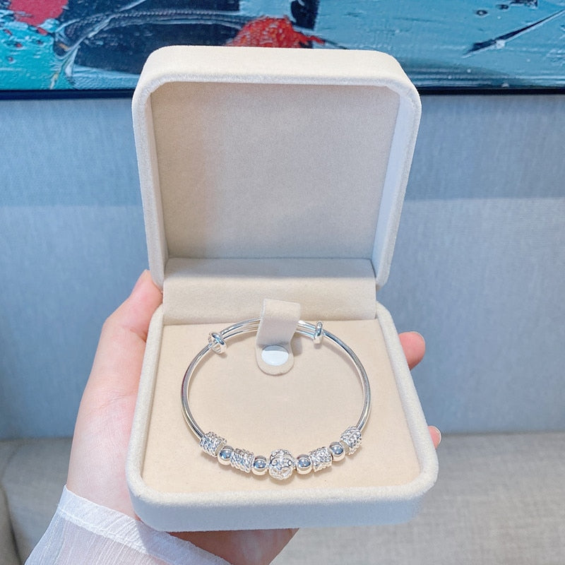 Women's shimmering silver luck bead bracelet, a stylish and elegant accessory.