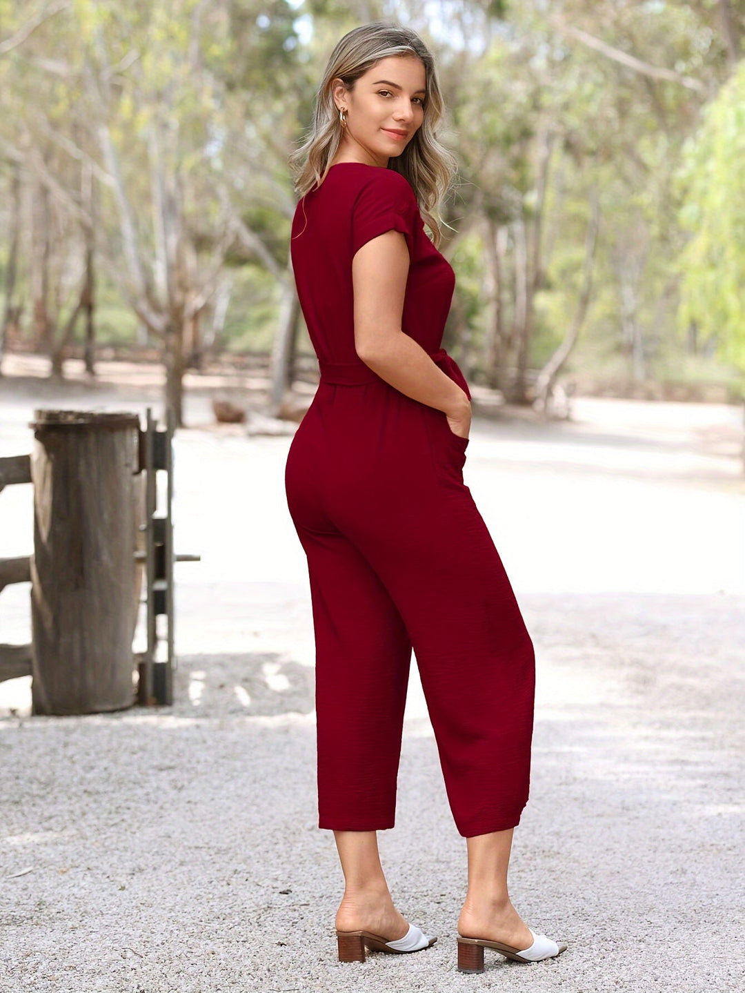 Elegant women's jumpsuit, V-neck, short sleeves, and a chic waist belt detail.