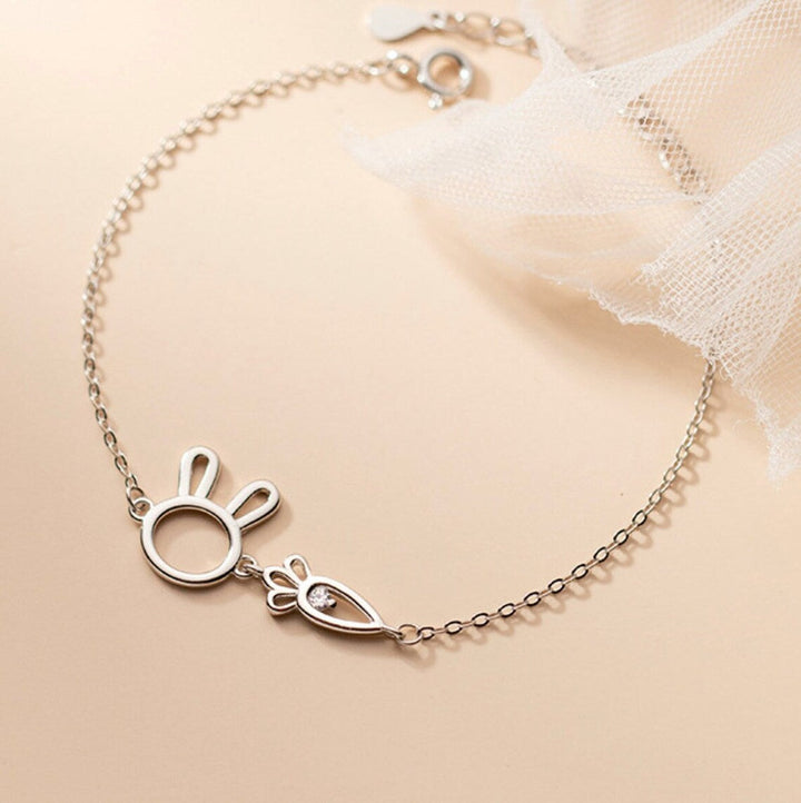 Close-up of a detailed silver rabbit pendant on an adjustable women's charm bracelet. Whimsical jewelry.
