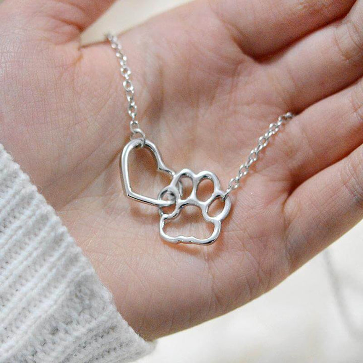 Close-up of a delicate paw print heart necklace, a beautiful tribute for any animal lover.
