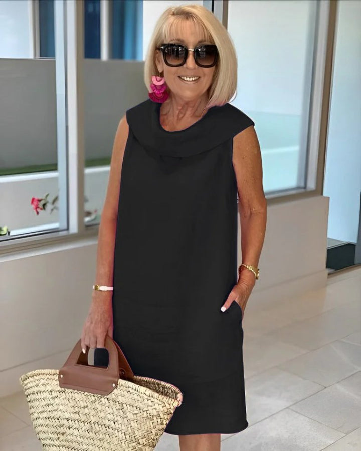 Elegant women's cowl neck shift dress featuring convenient pockets. Sleeveless, knee-length, & comfortable for casual wear.
