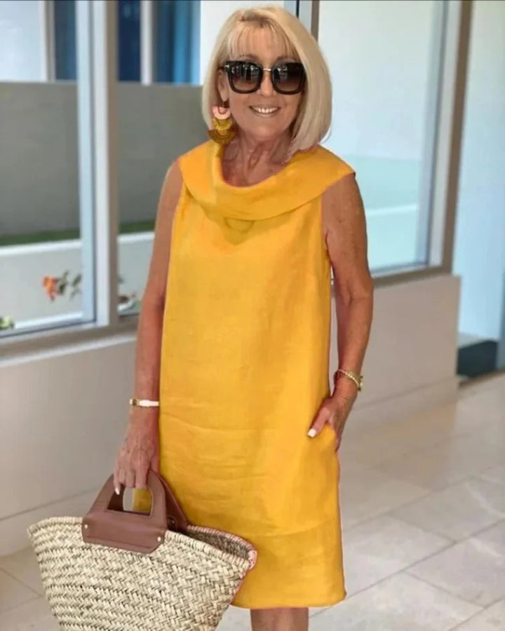 Comfortable women's casual shift dress with a chic cowl neck and practical pockets. Sleeveless, relaxed fit.