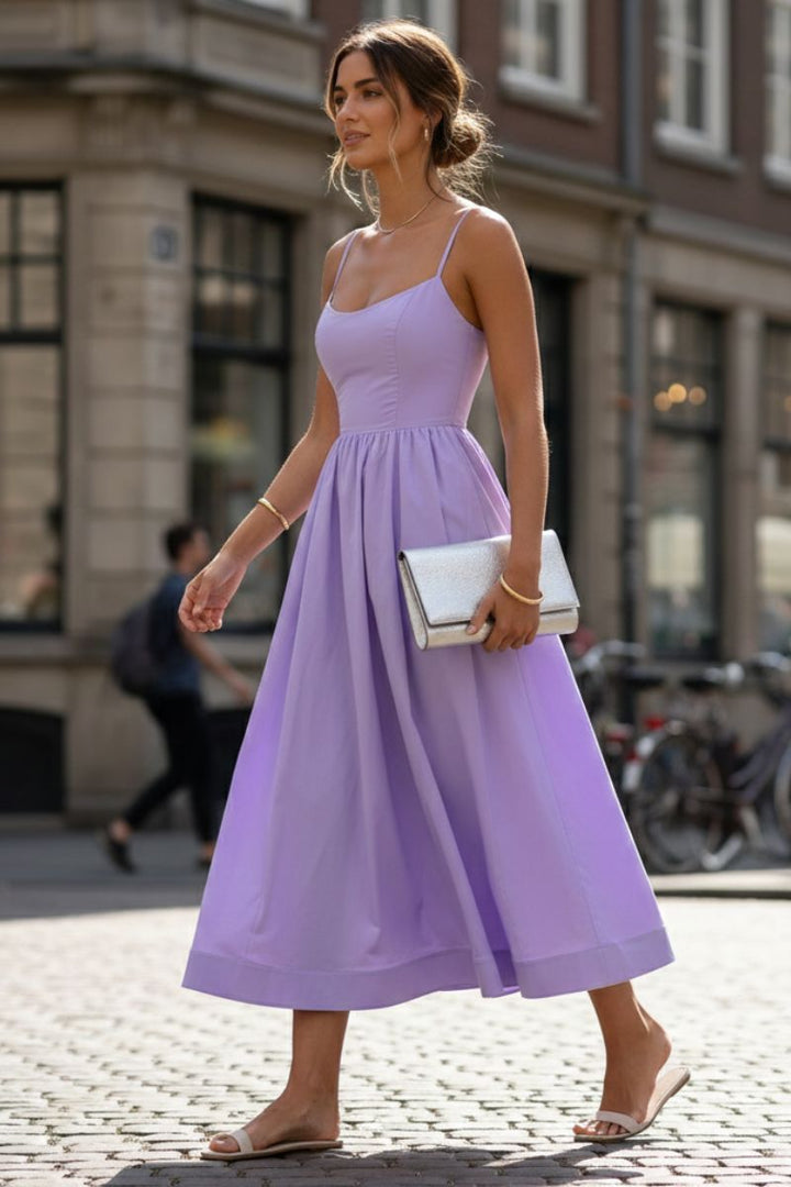 Woman wearing a flattering sleeveless scoop neck midi dress, perfect for cocktail parties.