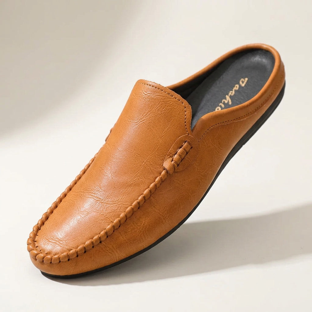 Women's slip-on mule loafers with elegant hand-stitched detail. Comfortable flat shoes for casual style.