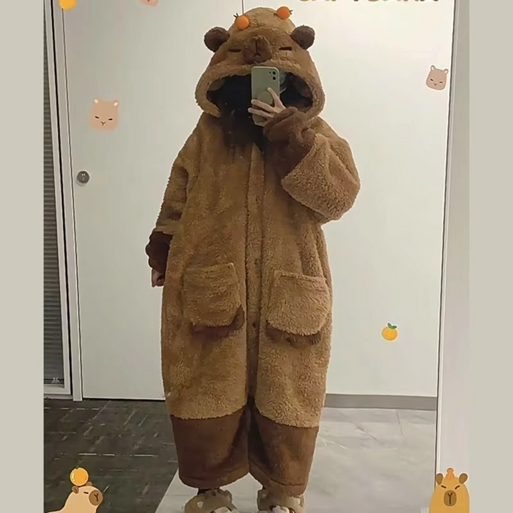 Woman relaxing in a cute capybara hooded pajama set. Soft, cozy, kawaii sleepwear and loungewear for women.
