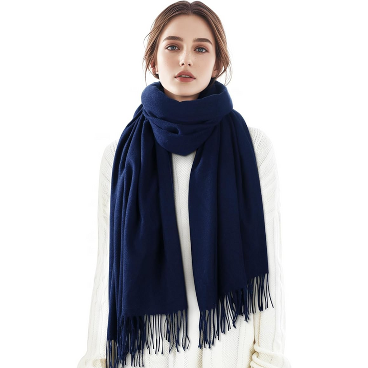 Woman wearing a draped cashmere blend plaid scarf, grey and white pattern, elegant winter fashion accessory.