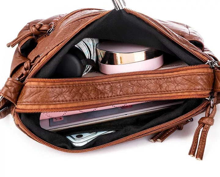 Stylish black women's soft leather shoulder bag with adjustable strap, ideal for practicality and everyday wear.