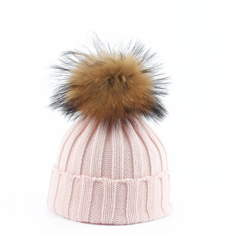 Elegant women's navy knitted winter hat adorned with a chic faux fur pom-pom, a must-have accessory