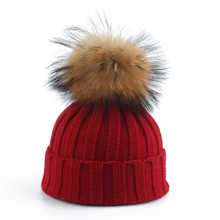 Fashionable women's mustard yellow knit beanie with a contrasting faux fur pom-pom for winter style