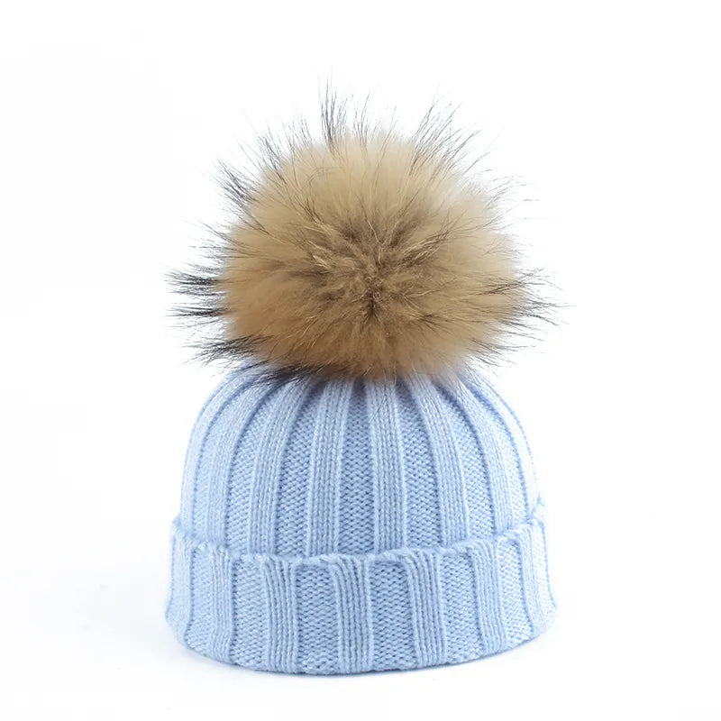 Warm women's white cable knit winter beanie topped with a generous faux fur pom-pom, ultimate comfort