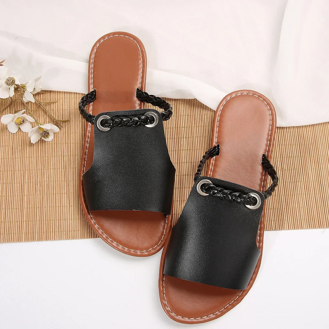 Woman wearing comfortable braided thong flat sandals, showcasing casual summer style.
