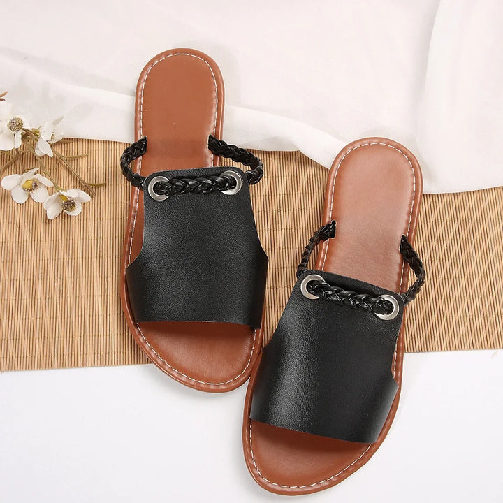 Woman wearing comfortable braided thong flat sandals, showcasing casual summer style.