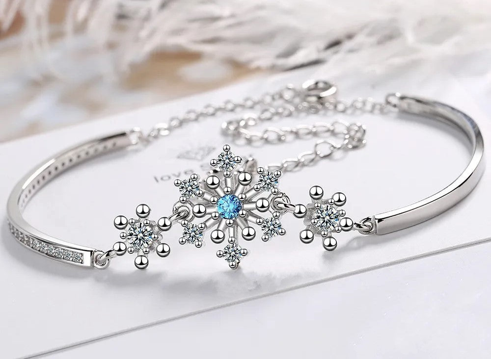 Elegant women's Christmas snowflake bracelet with sparkling cubic zirconia. Adjustable holiday jewelry.
