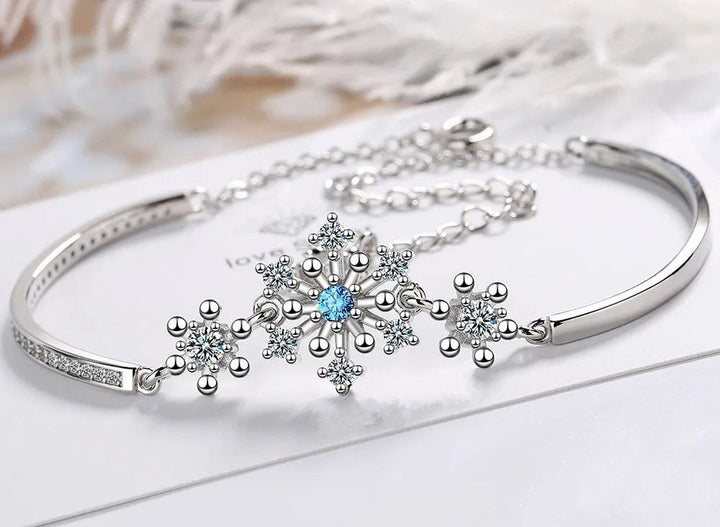 Elegant women's Christmas snowflake bracelet with sparkling cubic zirconia. Adjustable holiday jewelry.