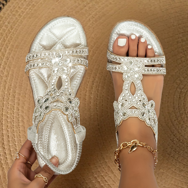 Fashionable women's rhinestone flat summer sandals on foot, offering comfortable and sparkling casual footwear.