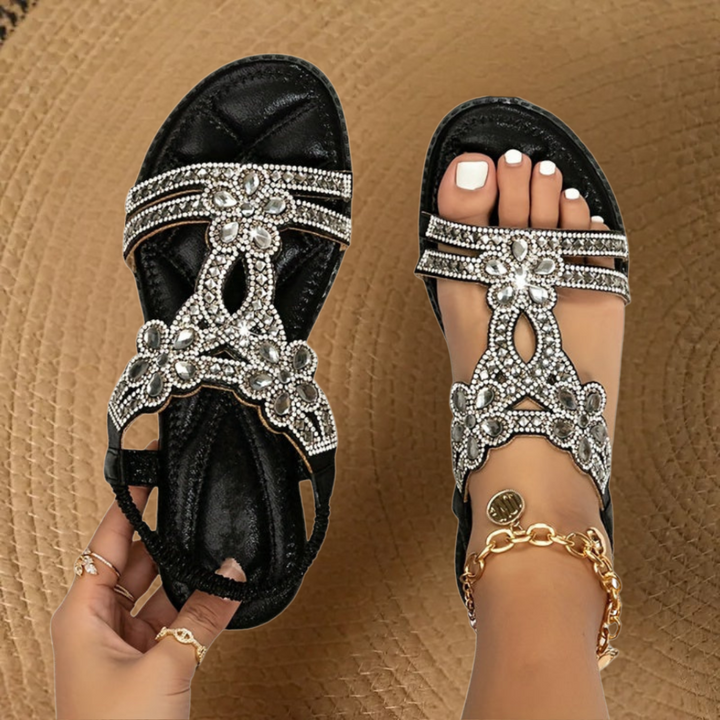 Top view of women's open-toe flat summer sandals, featuring sparkling rhinestone straps for elegant casual wear.